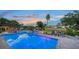 Beautiful pool and jacuzzi overlooking canal at dusk with outdoor seating and meticulous landscaping at 5500 Merrimac Dr, Sarasota, FL 34231