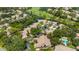 An aerial view showcasing a community, golf course, and scenic lake amidst lush greenery at 5626 Pipers Waite # 22, Sarasota, FL 34235