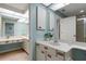 Bright bathroom with dual vanities, light blue walls and modern fixtures at 5626 Pipers Waite # 22, Sarasota, FL 34235