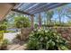 Charming courtyard featuring stone accents, lush plants, and a pergola for shade and visual interest at 5626 Pipers Waite # 22, Sarasota, FL 34235