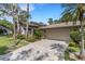 Charming home exterior featuring a paved driveway, two-car garage, and lush landscaping at 5626 Pipers Waite # 22, Sarasota, FL 34235