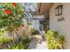 Inviting front entrance with a stone pathway, lush landscaping, and a pergola, leading to a glass-paneled front door at 5626 Pipers Waite # 22, Sarasota, FL 34235