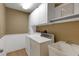 Functional laundry room features a utility sink and extra white storage cabinets at 5626 Pipers Waite # 22, Sarasota, FL 34235