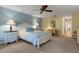 Comfortable main bedroom featuring two bedside tables with lamps, a ceiling fan, and a work area at 5626 Pipers Waite # 22, Sarasota, FL 34235