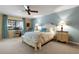 Comfortable main bedroom featuring two bedside tables with lamps, a ceiling fan, and a work area at 5626 Pipers Waite # 22, Sarasota, FL 34235