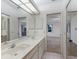 Bathroom features a double sink vanity with storage cabinets, large mirror and tile flooring at 5712 Garden Lakes Dr, Bradenton, FL 34203