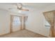 Well-lit bedroom with two windows dressed with blinds and draperies and neutral carpet at 5712 Garden Lakes Dr, Bradenton, FL 34203