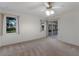 Well-lit bedroom featuring two windows, sliding glass doors, and a ceiling fan with light fixture at 5712 Garden Lakes Dr, Bradenton, FL 34203