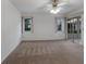Spacious bedroom featuring two windows, sliding glass doors, and a ceiling fan with light fixture at 5712 Garden Lakes Dr, Bradenton, FL 34203