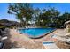 Community pool with multiple lounge chairs, sunny skies, and adjacent to a bath house at 5712 Garden Lakes Dr, Bradenton, FL 34203