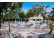 Community pool surrounded by lush landscaping, tables and chairs, and bright sunny skies at 5712 Garden Lakes Dr, Bradenton, FL 34203