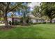 Charming home featuring a two-car garage, red tile roof, and mature trees at 5712 Garden Lakes Dr, Bradenton, FL 34203
