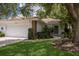 Charming home featuring a two-car garage, red tile roof, and lush landscaping at 5712 Garden Lakes Dr, Bradenton, FL 34203