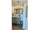 Well-lit bathroom featuring modern grey vanity with chevron-patterned mirror and dark wood flooring at 5855 Midnight Pass Rd # 621, Sarasota, FL 34242