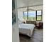 Bright bedroom boasts large windows with stunning outdoor views, ceiling fan, and wood-look floors at 5855 Midnight Pass Rd # 621, Sarasota, FL 34242