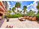 Outdoor kitchen area with a table, brick grills, and mature palms and landscape providing a relaxing ambiance at 5855 Midnight Pass Rd # 621, Sarasota, FL 34242