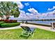 Inviting waterfront with lounge chairs overlooking the ocean with boat access and palm trees on a manicured lawn at 5855 Midnight Pass Rd # 621, Sarasota, FL 34242