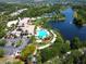 This aerial view showcases a luxury community with a pool, tennis courts, lake, and beautifully landscaped grounds at 5877 Ferrara Dr, Sarasota, FL 34238