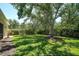 Well-maintained backyard with lush lawn, mature trees, and manicured shrubbery for serene outdoor enjoyment at 5877 Ferrara Dr, Sarasota, FL 34238
