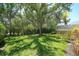 Expansive backyard featuring mature trees, manicured hedges and pool enclosure offers plenty of privacy at 5877 Ferrara Dr, Sarasota, FL 34238