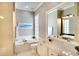 Bright bathroom features a soaking tub, white vanity, and abundant natural light at 5877 Ferrara Dr, Sarasota, FL 34238