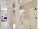 Bright bathroom boasts white cabinets and modern glass shower, leading to the bedroom at 5877 Ferrara Dr, Sarasota, FL 34238