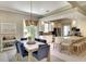 Dining area with a modern table, blue chairs, and views of the kitchen with a breakfast bar at 5877 Ferrara Dr, Sarasota, FL 34238
