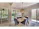 Bright dining room with modern light fixture, table with seating for six, and access to outdoor living spaces at 5877 Ferrara Dr, Sarasota, FL 34238