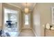 Inviting foyer with a light-colored rug, a pendant light, and an open view to a room with an arched window at 5877 Ferrara Dr, Sarasota, FL 34238