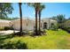 Beautiful single-story home with a well-manicured lawn and lush landscaping, including mature palm trees at 5877 Ferrara Dr, Sarasota, FL 34238