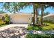 Charming single-story home with a tile roof, brick driveway and manicured front yard with palm trees at 5877 Ferrara Dr, Sarasota, FL 34238