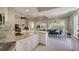 Open concept kitchen and dining area featuring granite countertops, white cabinetry, and bright, airy living space at 5877 Ferrara Dr, Sarasota, FL 34238
