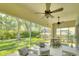Screened-in lanai with ceiling fans provides a relaxing outdoor living space overlooking a lush garden at 5877 Ferrara Dr, Sarasota, FL 34238