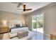 Bedroom featuring a ceiling fan, sliding glass doors to the backyard, and wood flooring at 5877 Ferrara Dr, Sarasota, FL 34238