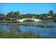Scenic community pond with a charming bridge, lush vegetation, and palm trees creating a peaceful atmosphere at 5877 Ferrara Dr, Sarasota, FL 34238