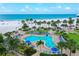 Aerial view of a pool steps from the beach and surrounded by palm trees at 5916 Midnight Pass Rd # 404, Sarasota, FL 34242