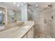 Bathroom with long vanity, glass shower, tile, and modern lighting fixtures at 5916 Midnight Pass Rd # 404, Sarasota, FL 34242