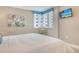 Relaxing bedroom with a comfortable bed, mounted TV, cornice covered window, and neutral walls at 5916 Midnight Pass Rd # 404, Sarasota, FL 34242