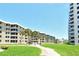 Beautiful condo complex with manicured lawns, palm trees, and inviting walkways for a peaceful community atmosphere at 5916 Midnight Pass Rd # 404, Sarasota, FL 34242