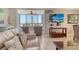 Bright living room showcasing comfortable seating with view through the screened-in lanai to the ocean at 5916 Midnight Pass Rd # 404, Sarasota, FL 34242