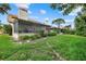 Wide backyard featuring a screened-in patio and lush greenery, with a glimpse of neighboring properties at 6207 Courtside Dr # 23, Bradenton, FL 34210