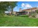 Spacious backyard featuring a screened-in patio, lush greenery, and a well-maintained lawn at 6207 Courtside Dr # 23, Bradenton, FL 34210
