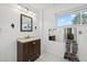 Bright bathroom with window, a dark wood vanity, a decorative mirror, and towel rack at 6207 Courtside Dr # 23, Bradenton, FL 34210