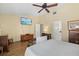 Well-lit bedroom with a ceiling fan, wood floors, and a television mounted on the wall at 6207 Courtside Dr # 23, Bradenton, FL 34210