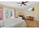Bright bedroom with ceiling fan, a door to balcony, wood floors, and a wall-mounted television at 6207 Courtside Dr # 23, Bradenton, FL 34210