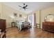 Charming bedroom features a ceiling fan, hardwood floors, a bed with lamps, and an antique vanity at 6207 Courtside Dr # 23, Bradenton, FL 34210