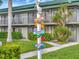 Exterior shot of building with palm trees, directional sign, and manicured lawn at 7150 N Tamiami Trl # S-623, Sarasota, FL 34243