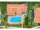 Aerial view of a home with a terracotta roof, a swimming pool, and a sun deck, surrounded by lush greenery at 7179 Boca Grove Pl # 202, Lakewood Ranch, FL 34202