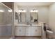 This bathroom features double sinks, decorative mirrors, and bright lighting, along with a glass-enclosed shower at 7179 Boca Grove Pl # 202, Lakewood Ranch, FL 34202