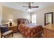 Cozy bedroom with ceiling fan, natural light, decorative bedding, and wood furnishings at 7179 Boca Grove Pl # 202, Lakewood Ranch, FL 34202